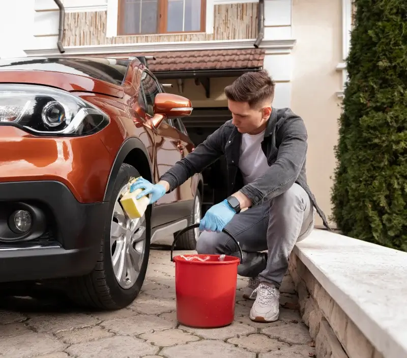 Lavage auto à domicile Tremblay-les-Villages : professionnel intervenant sur un véhicule